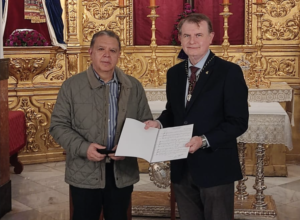 Juan Antonio Esmerado Rodríguez entrega a José Antonio Manzano las partituras de la nueva composición.